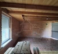 Wooden ceiling and brick walls in the cabin, floor with wooden decor.