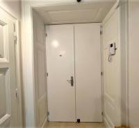 Entrance hallway with white doors and tiled floor in a 2-room apartment.