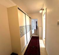 Hallway of a 2-room apartment with flooring, a wardrobe, and a carpet.