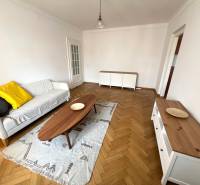 Living room with wood-patterned flooring, a sofa, and a wooden coffee table.