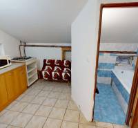 A small kitchen in a 3-room apartment with a microwave and a bathroom with a bathtub.
