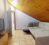 Living room in the attic of a 3-room apartment with a sofa and a television.