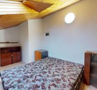 Attic room with a bed and wooden decor in a 3-room apartment.