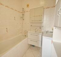 Bathroom in a 3-room apartment with a bathtub, mirror, and washing machine.