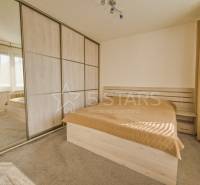 A bedroom with a large built-in wardrobe and a bed in a 3-room apartment.