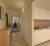 A kitchen in a 3-room apartment with white cabinets and a built-in sink.