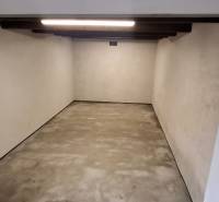 Empty garage with concrete floor and lighting.
