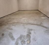 An empty garage with a concrete floor and tire marks.