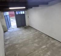 An empty garage with a concrete floor and a wooden ceiling.