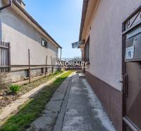 A narrow path between the buildings of a family house in Horná Potôň with a small garden.