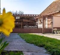 A family house in Horná Potôň with a lawn, yellow flower, and brown gate.