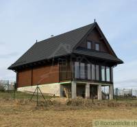 A family house in Lom nad Rimavicou with wooden cladding and a glass veranda.