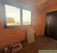 Interior of a family house with wooden decor, large window, and doors.