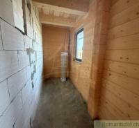 A narrow space with wooden paneling and a brick wall in a family house.