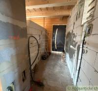 A construction in a family house with unfinished walls and wooden ceilings.