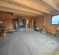 The interior of a family house with wooden walls and a tiled stove, an unfinished room.