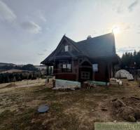 A family house in Lom nad Rimavicou, surrounded by natural scenery and hilly terrain.