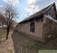 An older family house in Čalovec surrounded by trees and open nature.