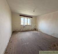 A room in a family house with a wooden decor floor and a large window.