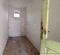 A narrow space with wooden doors and a small window in a family house.