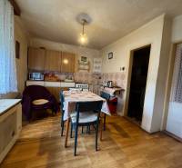 A kitchen in a family house with a wooden decor floor, a dining table, and furniture.