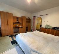 A bedroom in a family house with wooden furniture and a floor with a wood decor.