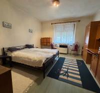 A bedroom in a family house with a comfortable bed and simple furniture.