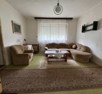 Living room in a family house with a comfortable sofa set and a carpet.