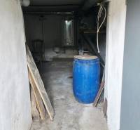 The basement of a family house with a blue barrel and a boiler on the wall.