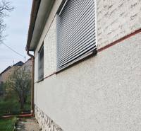 Exterior of a family house in Trstín with a stone plinth and shutters on the windows.