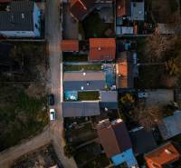A view from above of family houses in Poprad with visible roofs and a road.