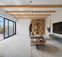 Living room in a family house with wooden beams and large glass doors.
