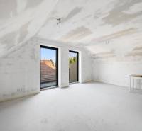 A bright attic room in a family house with neutral tones and large windows.