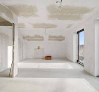 A spacious room in a family house with large windows and an empty floor.