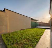 The garden of a family house in Poprad with greenery and a paved walkway.