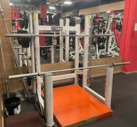Fitness center with exercise machines and mirrors, floor with wooden decor.