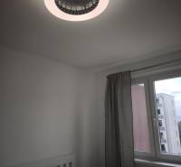 A bedroom in a 2-room apartment with modern lighting and a window with a view.