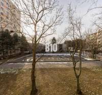 A winter view of apartment buildings and a sidewalk with trees on Račianska in Bratislava III.