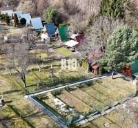 Gardens with cottages in Martin, surrounded by trees and grassy areas.