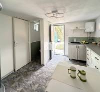 The interior of the cottage with a practical kitchen and dining area in a simple style.