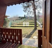 The veranda of the cottage in Martin with a view of the landscaped garden with a lawn.