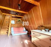 The interior of a cabin with wooden paneling and a sofa, on a floor with a wooden decor.