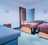 Bedroom in a 3-room apartment with two beds, nightstands, and a sofa.