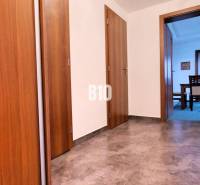 A hallway with tiles and doors leading to a room in a 3-room apartment.