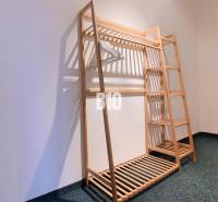 A wooden stand with hangers in a 3-room apartment on a dark carpet.