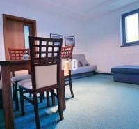 Dining room in a 3-room apartment with wooden furniture and blue flooring.