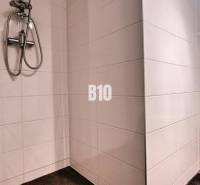 Bathroom in a 3-room apartment with white tiles, a shower, and a toilet.