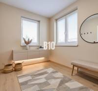 Interior of a family house with a bench, a round mirror, and a floor with a wooden decor.