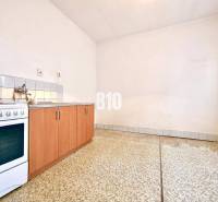 A kitchen in a family house with a kitchen unit, a stove, and a tiled floor.