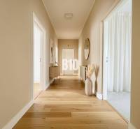 A hallway in a family house with a wooden decor floor and simple furnishings.